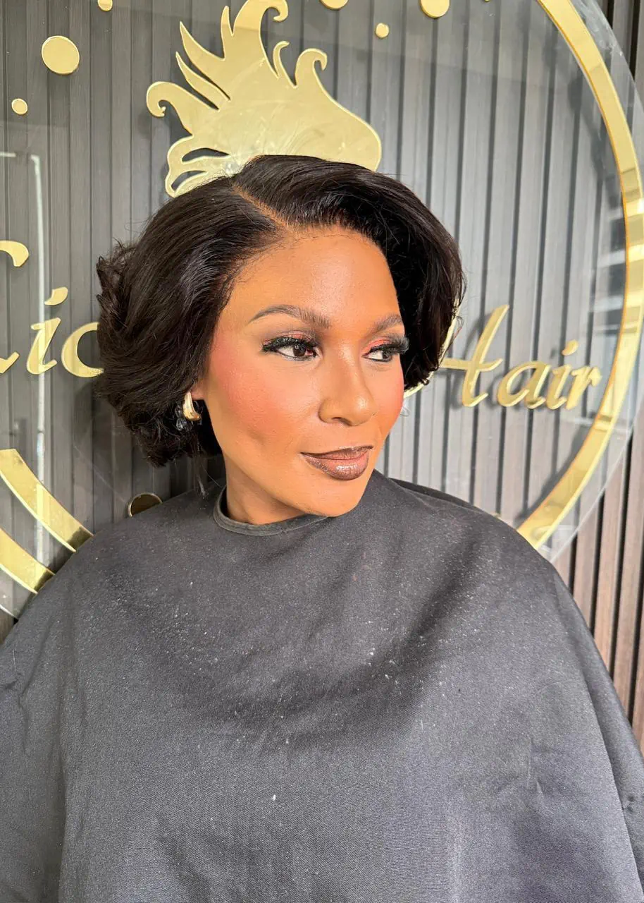 Woman wearing a short, side-parted black bob with soft curls at Licious Hair salon
