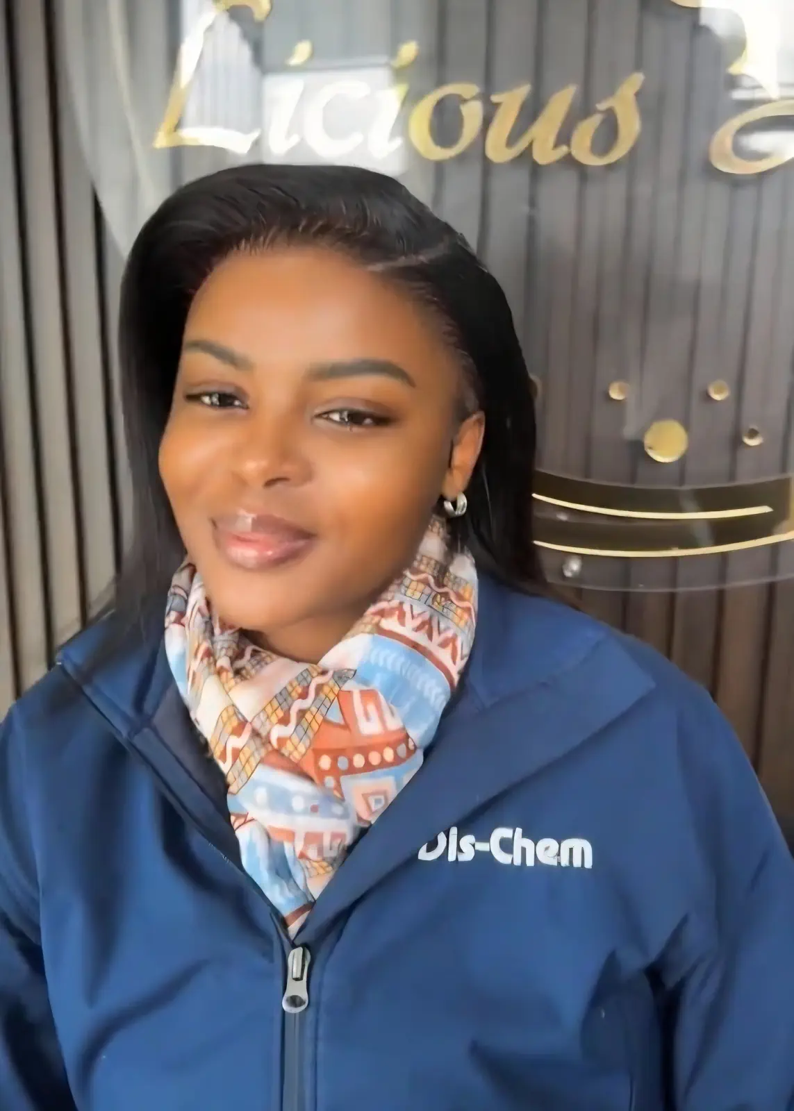 Woman wearing a sleek, side-parted black hairstyle at Licious Hair salon