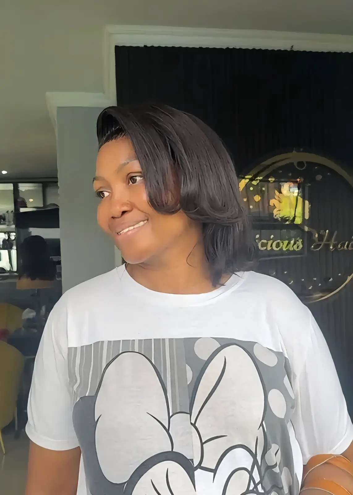 Woman wearing a smooth, shoulder-length black bob with curled-under ends at Licious Hair salon