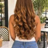 The Golden Belle 24-inch 4/27 bouncing curls wig, rear view on a model.